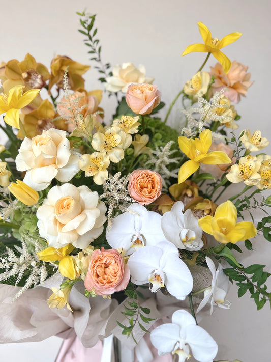 Grand opening floral stand with peach, yellow, and white seasonal flowers