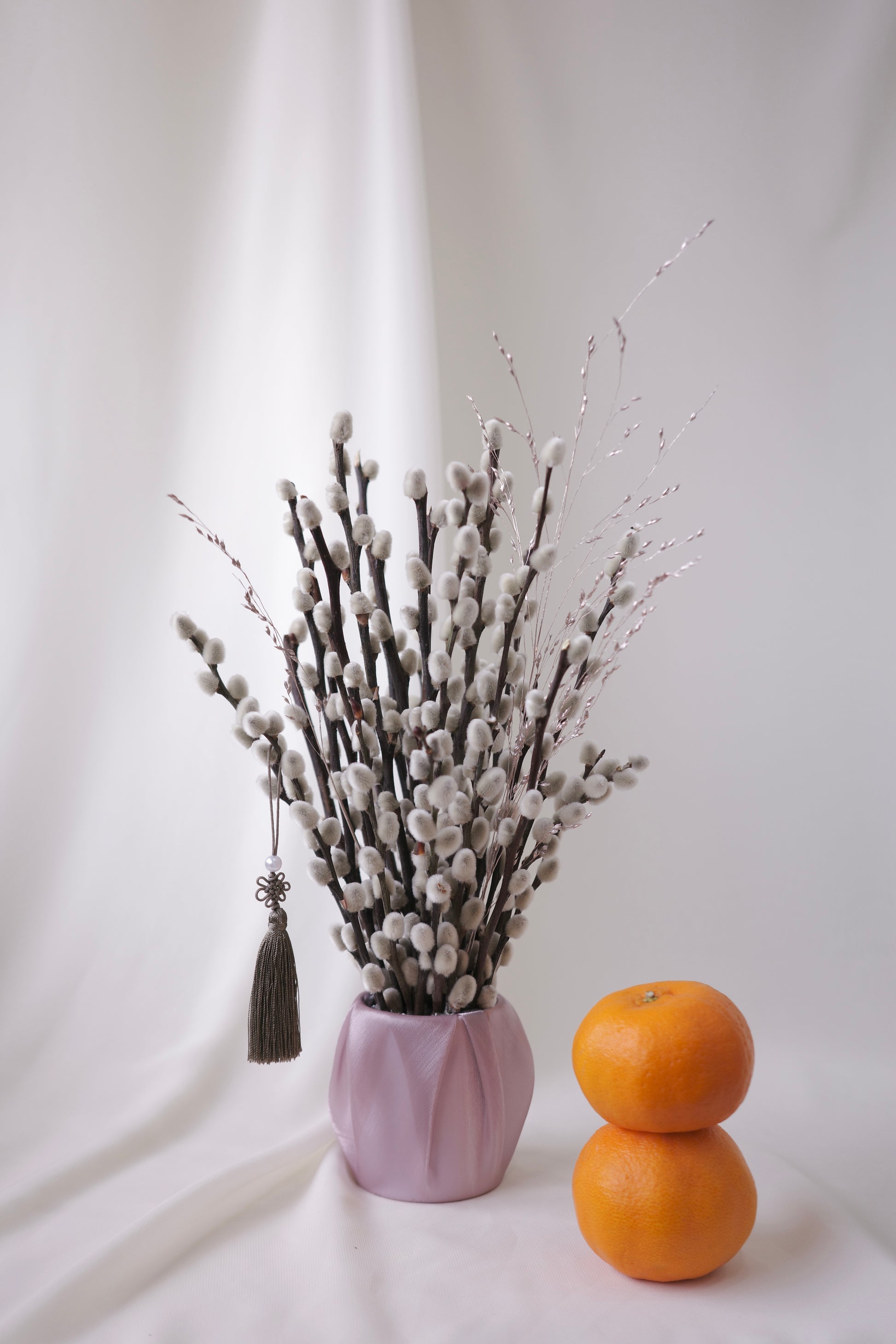 Petite silver pussy willow branches in a blush pot, with tassel