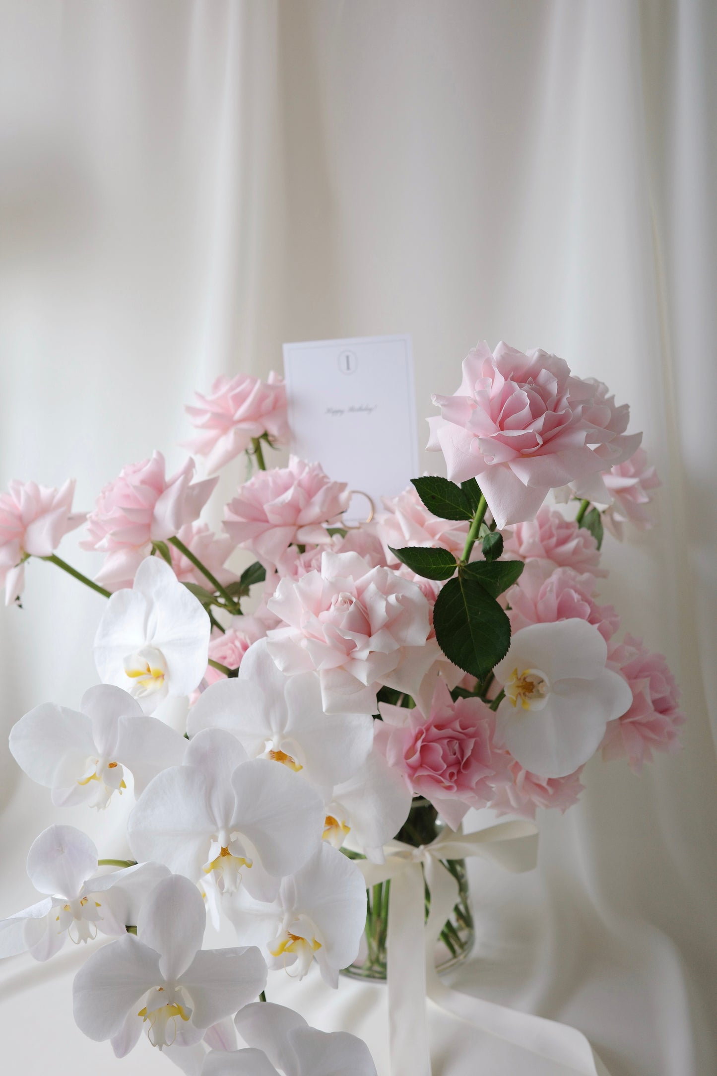 Luxury pink rose and orchid floral arrangement in a glass vase, perfect for birthdays and anniversaries.