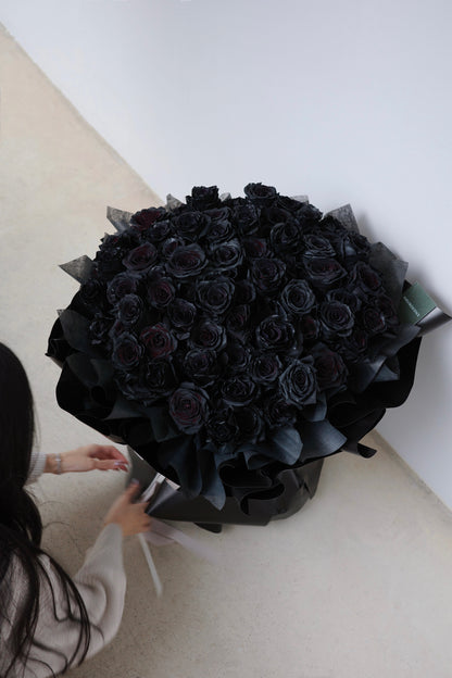 Luxurious bouquet of 99 black roses, hand-arranged to symbolize eternal love and devotion,  the perfect statement of romance and passion.