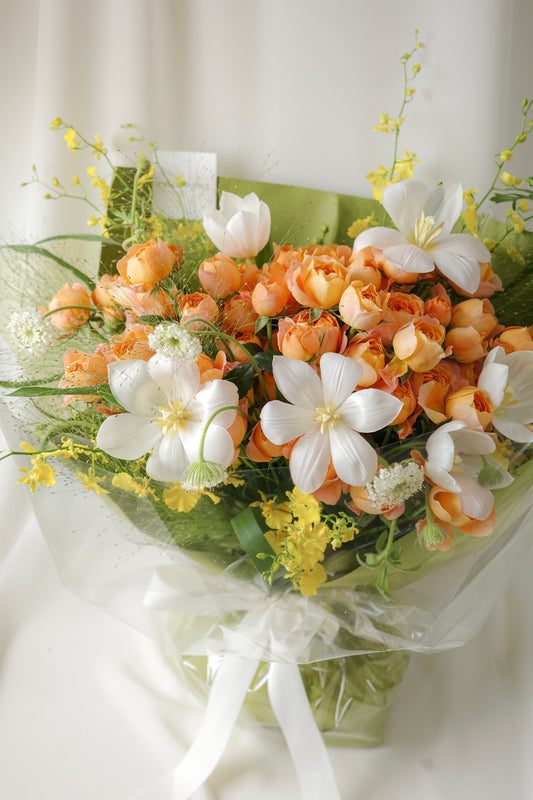 Fresh bouquet of orange roses, white blooms, and yellow accents with airy blooms, a cheerful arrangement perfect for birthdays and celebrations.