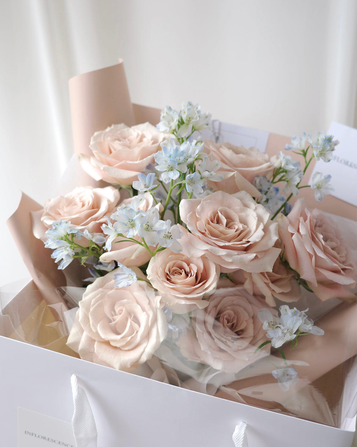 Romantic bouquet of nude pink roses and blue delphiniums by Studio Inflorescence Singapore