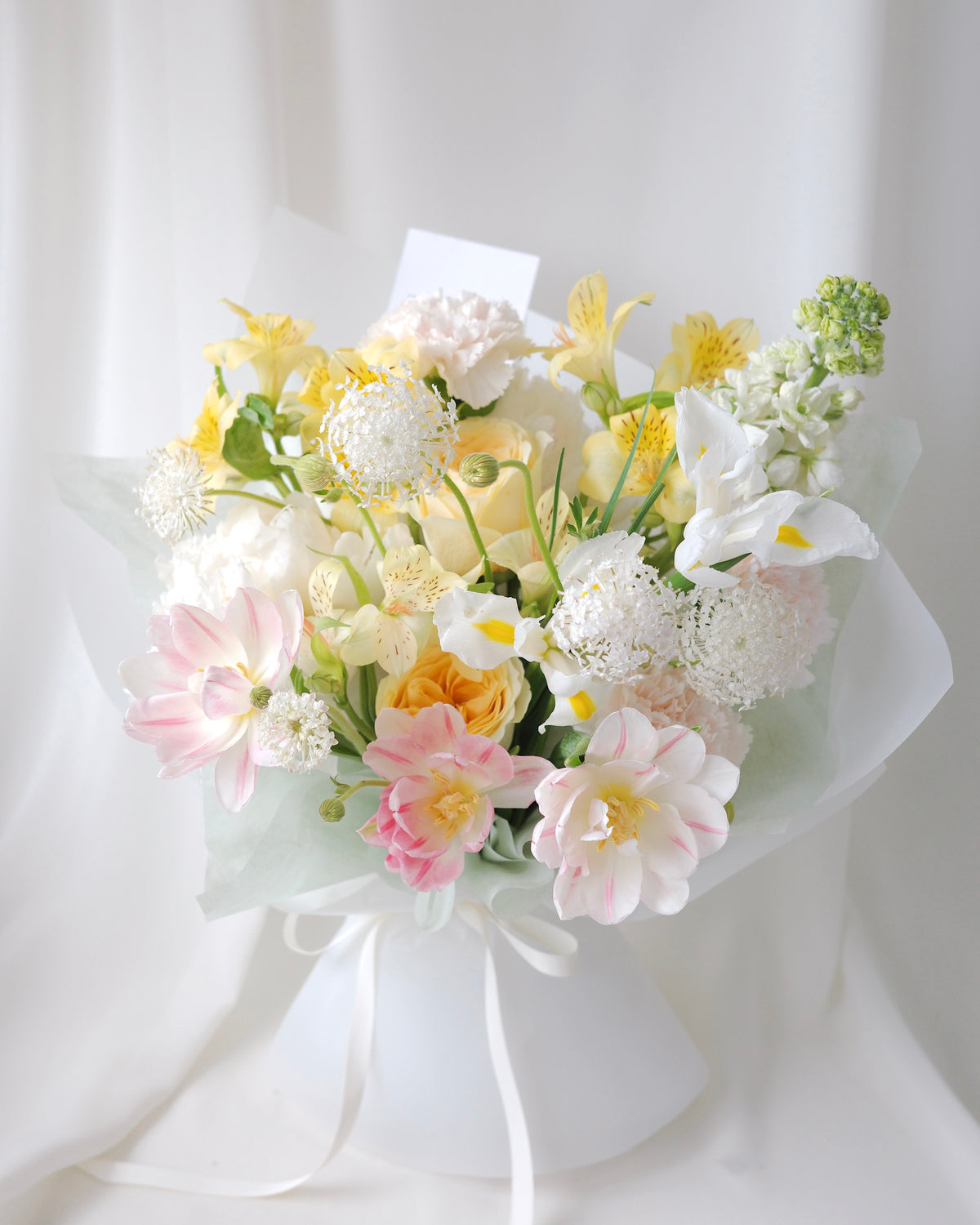 Seasonal bouquet in blush pink, butter yellow, white, and green by Studio Inflorescence Singapore