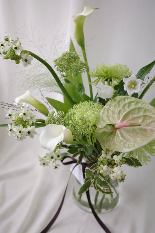 Green botanical vase arrangement with lush foliage, sculptural branches, and fresh seasonal flowers by Studio Inflorescence Singapore